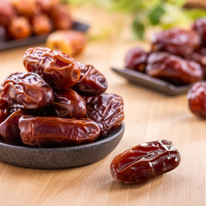 Dried Khidri dates on a wooden surface with a blurred background